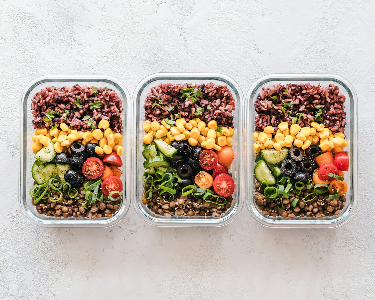 Three glass meal prep containers filled with rice and vegetables