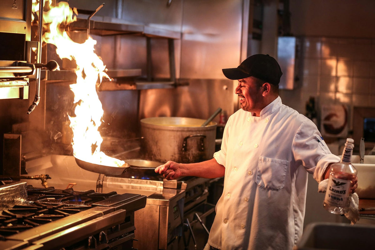 A cook working at the stove in a kitchen